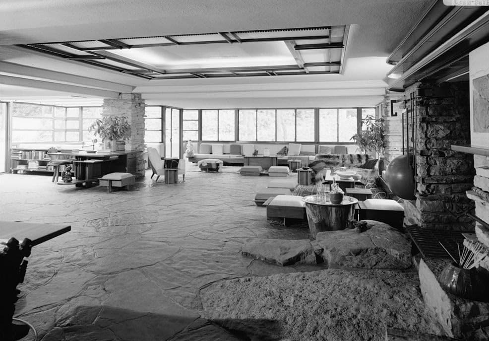 The living room, with the boulder hearth and stairs down to the stream · HABS, public domain