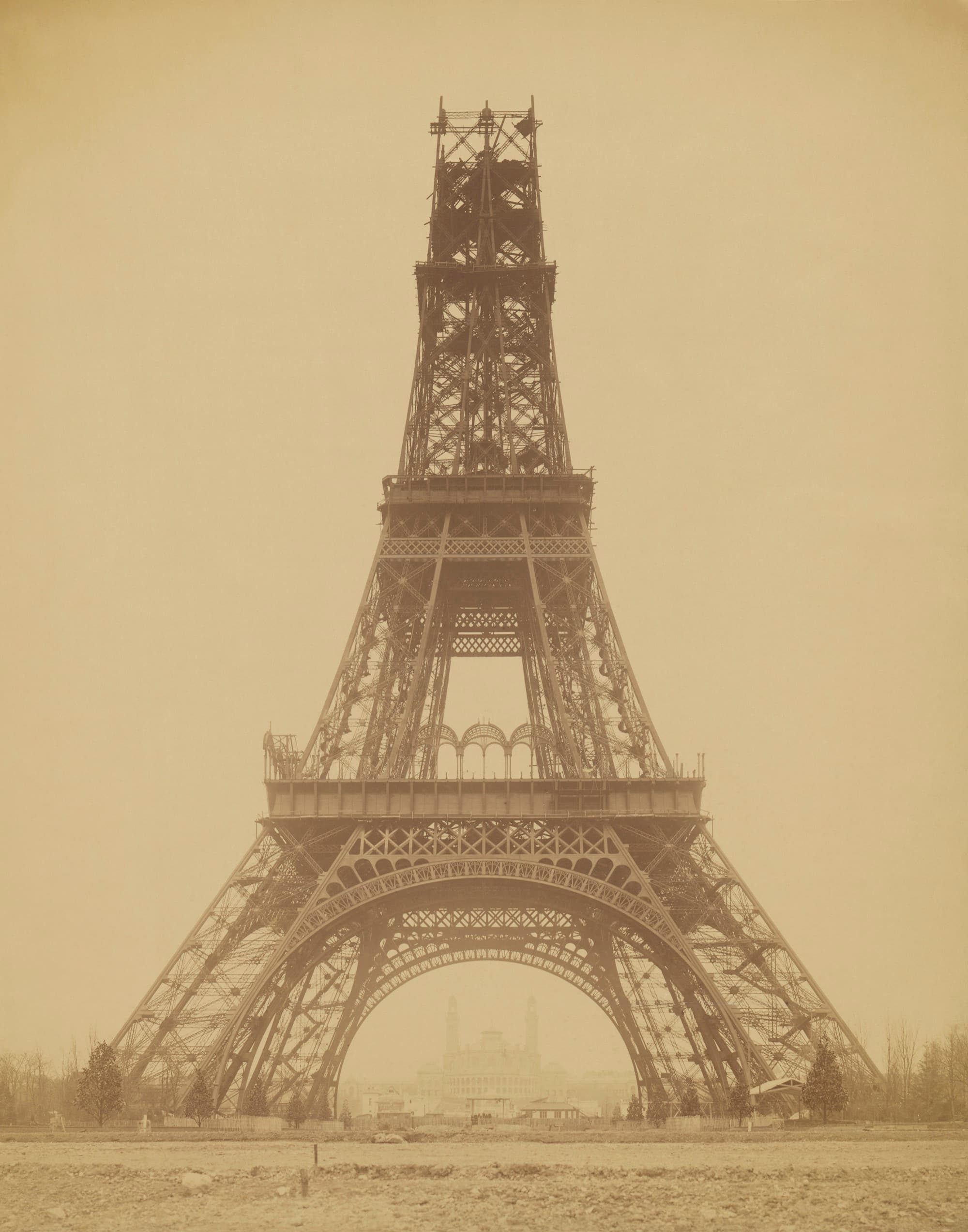 The tower mid-construction in 1888, its iron legs rising over Paris. Photo by Louis-Émile Durandelle, 1888. Public domain.